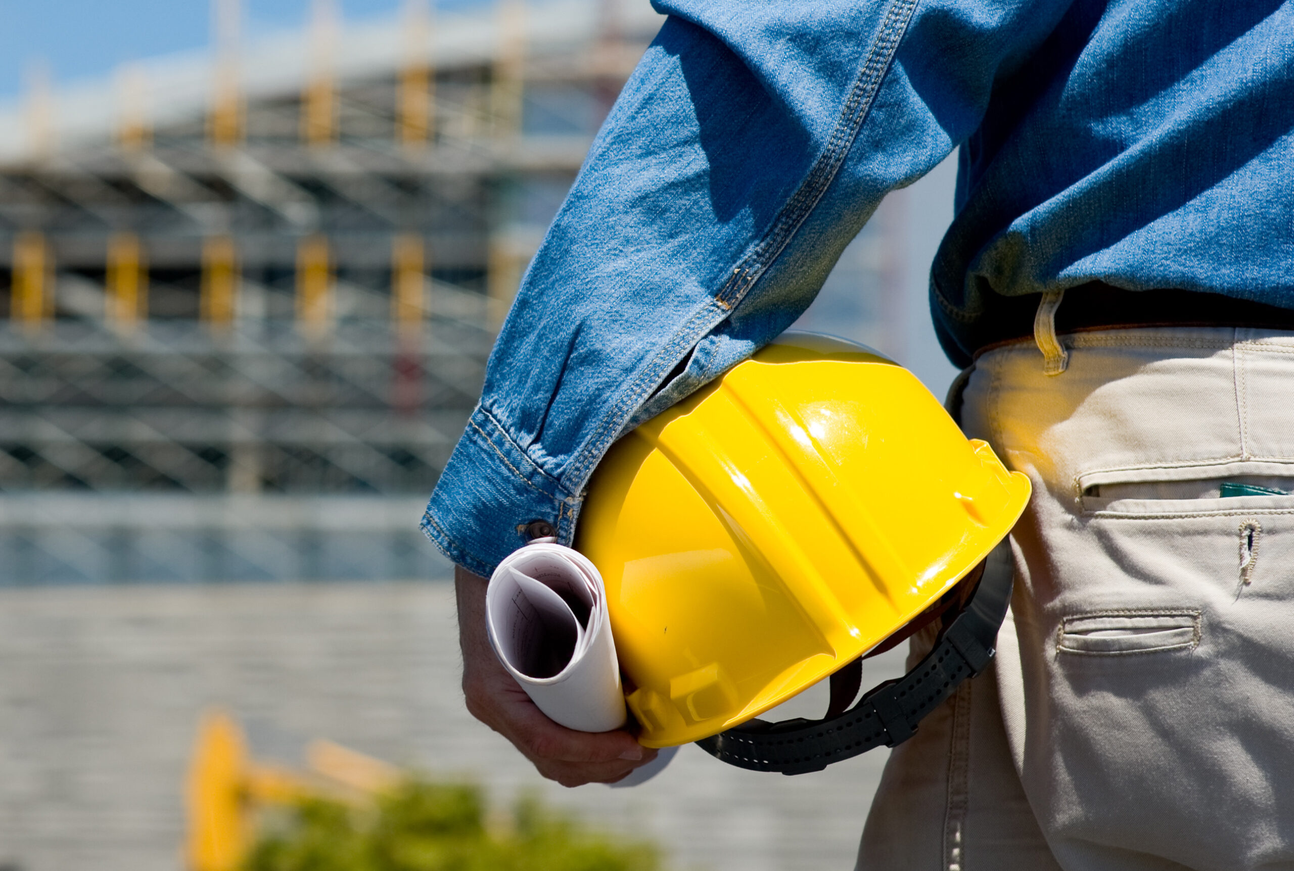 A construction worker or foreman at a construction site observing the progress of construction job or project, with copy space